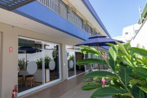 a building with a blue umbrella and a patio at K1 RESIDENCE Campinas in Campinas
