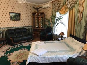 - une chambre avec un lit et deux fauteuils en cuir dans l'établissement Lorena, à Odessa