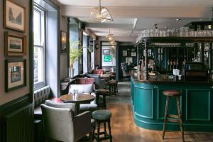 een bar met tafels en stoelen in een kamer bij Rose And Crown Hotel in Londen