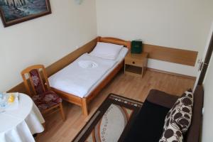 ホイニツェにあるHotel Poloniaの小さなベッドとテーブルが備わる小さな客室です。
