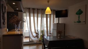 een woonkamer met een groot raam met gordijnen bij T2 in Gruissan