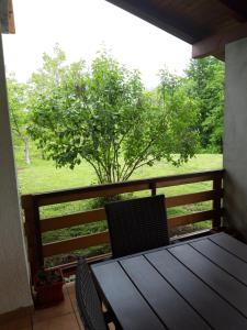 una mesa y sillas en un porche con una valla en Apartment Sanja, en Smoljanac
