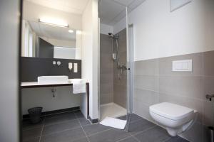 ein Bad mit einer Dusche, einem WC und einem Waschbecken in der Unterkunft Rosa Flesch Hotel und Tagungszentrum in Waldbreitbach