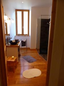 a bathroom with a shower and a kitchen with a table at Gite de l'Amistat in Vicdessos