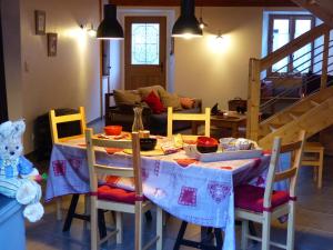a dining room with a table and chairs with a table and a table at Gite de l'Amistat in Vicdessos