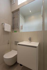 a bathroom with a sink and a toilet and a mirror at NoHo 132 Serviced Apartments by Concept Apartments in London