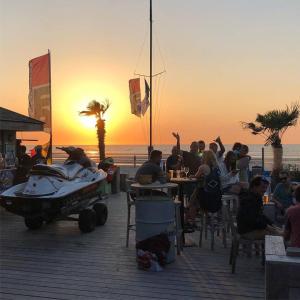 a group of people sitting at tables on the beach at Duinenblik 5 in Nieuwpoort