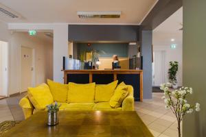 a yellow couch in a living room with a table at Kuressaare Central Hostel in Kuressaare