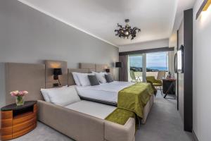 sypialnia z dużym łóżkiem i kanapą w obiekcie Hotel Omorika w Crikvenicy