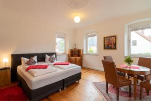 1 dormitorio con 1 cama, mesa y sillas en Exklusive Ferienwohnung Geisfeld, en Geisfeld