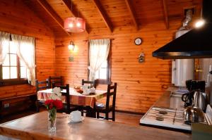 a dining room with a table in a wooden house at Cabañas El Chalten in Esquel