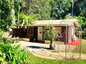 ein kleines Haus mit einem Zaun davor in der Unterkunft Curtis Cottage in Mount Tamborine