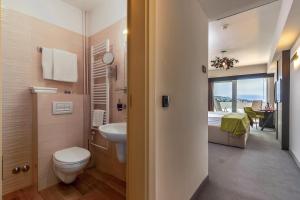 a bathroom with a toilet and a sink at Hotel Omorika in Crikvenica