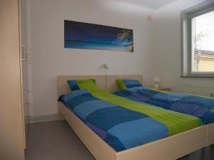 a bedroom with a bed with a blue and yellow blanket at Vestergade 7 Holiday Apartments in Frederikshavn