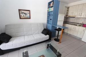 a living room with a couch and a table at Apartment overlooking to the pool 2450 in La Mata