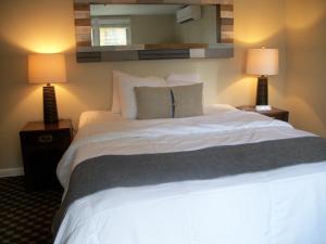 um quarto com uma grande cama branca e 2 candeeiros em Michillinda Lodge Resort em Whitehall