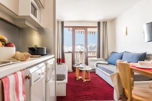 a kitchen and living room with a couch and a table at Résidence Pierre & Vacances Antarès in Avoriaz