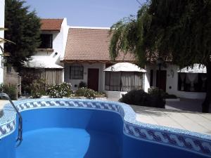 a blue swimming pool in front of a house at Complejo Tehuelches in Puerto Madryn