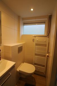a small bathroom with a toilet and a window at De Strandmus in Egmond aan Zee