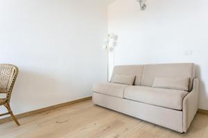 um sofá branco numa sala de estar com uma cadeira em Maison d'Orange - Port em Saint-Tropez