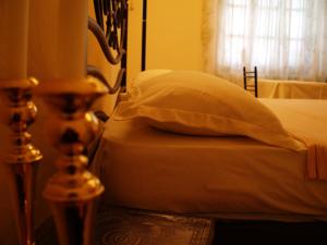 a bed with a pillow and a candle on a table at La Casa di Nonna in Qeparo