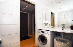uma casa de banho com uma máquina de lavar roupa e um lavatório em City center Oslo, Luxury Sørenga with sea view, 2 toilet, 2bedrooms em Oslo
