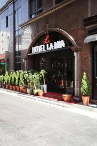 Residence Hotel Lamia في دايجون: صف من نباتات الفخار أمام فندق lambda
