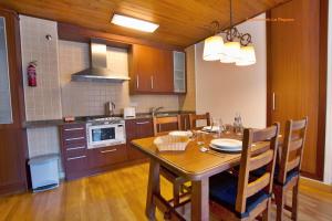 cocina con mesa de madera y comedor en Apartaments La Peguera II, en Barruera