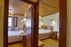 a bedroom with two beds and a door leading into a room at Apartaments La Peguera II in Barruera