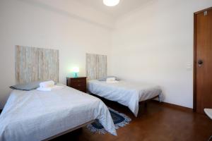 dwa łóżka siedzące obok siebie w pokoju w obiekcie Figueira da Foz Sunset Apartment w mieście Figueira da Foz