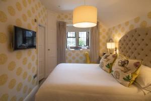 a bedroom with a large bed with a large white bedspread at Cragwood Country House Hotel in Windermere
