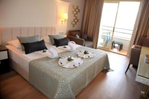 a hotel room with a bed with flowers on it at Fame Residence Kemer & Spa in Kemer
