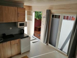 a small kitchen with wooden cabinets and a door to a patio at Apartament Antonio 1 Gdańsk in Gdańsk