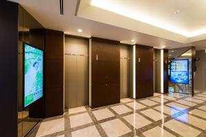 un corridoio con armadietti e televisore in un edificio di Super Hotel Premier Tokyo Station Yaesu-Chuoguchi a Tokyo