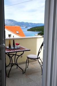 uma varanda com uma mesa e duas garrafas de vinho em Bella Vita em Korčula