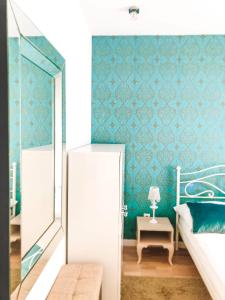 コウォブジェクにあるRezydencja Maritimo Kołobrzeg Portの青い壁のベッドルーム1室(ベッド1台付)
