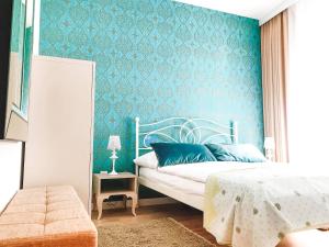 1 dormitorio con cama y pared azul en Rezydencja Maritimo Kołobrzeg Port, en Kołobrzeg