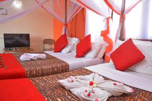 two beds in a room with red and white at Ocean View Nyali Boutique Hotel in Nyali