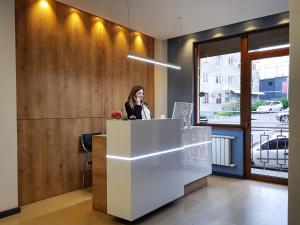 a woman standing at a counter in an office at Hotel Alpha in Yerevan