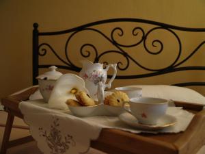 a tray with tea sets and cups on a bed at La Casa di Nonna in Qeparo