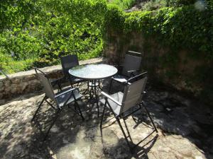 drie stoelen en een tafel en een tafel en stoelen bij Casa Burgués in Beceite