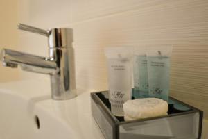 a bathroom sink with a container of toilet paper at St George Court, Spacious 2BR Apartments, City Centre, Self Check In, Parking, By DerBnB in Derby +82 photos
