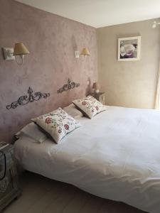 a bedroom with a large white bed with two pillows at Le Crillon in Murs