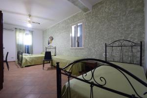 a bedroom with two beds and a room with a bed at Alba Tra I Pini B&B in Cefalù