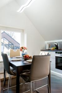 a kitchen with a table and chairs in a kitchen at Stylish, modern apartment near Vilnius Old Town in Vilnius
