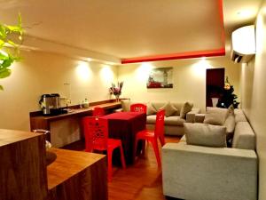 a living room with a table and red chairs at Eazy Hotel at Ampang in Batu Empat