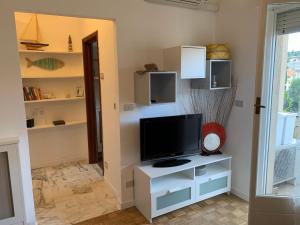 a living room with a tv on a white cabinet at Ocean in Bordighera