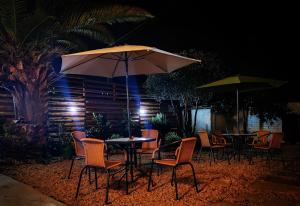 a table and chairs with an umbrella at night at Hostel Once Once in Villa de Leyva