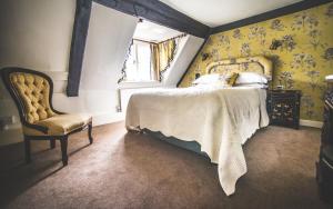 a bedroom with a bed and a chair and a window at Jeakes House in Rye