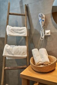 a towel rack and a basket on a table with towels at Mougre studios in Polychrono